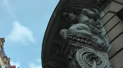 Pan down from carved stone statue over office door way to busy street. Stock Footage 1087129