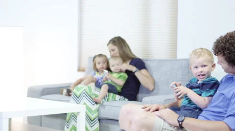 Pan down to father and son with cellphone and family Stock-Footage 67297511