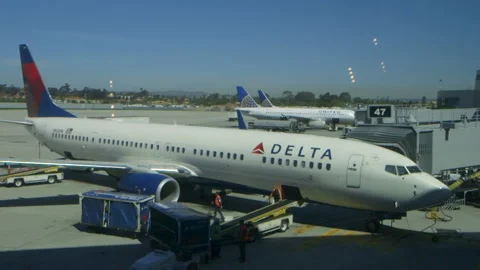 Pan Down from Gate to Delta Aircraft Stock Footage 141744256