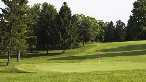 Pan Down on Golf Course Hole with flag in the Summer Stock-Footage 231240255