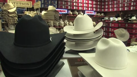 Pan down from hat sign to piles of cowboy hats in shop Austin TX Stock Footage 234274603