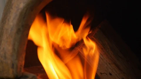 Pan down over wood burning in a chiminea 動画素材 115057766