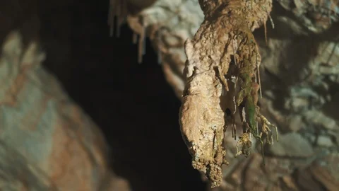 Pan down of a rock formation inside a cave with dripping water Stock Footage 94957340