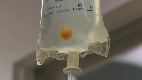 Pan down of saline drip IV bag, interior hospital. 스톡 동영상 111330266