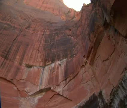 Pan down from sheer redrock cliffs to boulders Stock Footage 21681479