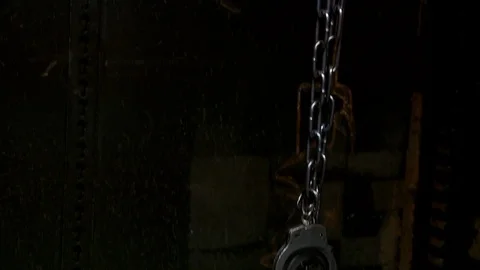 Pan down shot of chains leading to pile of handcuffs and chains. 스톡 동영상 106527994