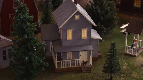 Pan down shot of model train village revealing farm house and barn Stock Footage 148605536
