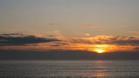 Pan down from sky to ocean at sunset with sun reflected on the water surface Stock Footage 116364091