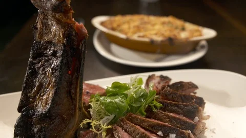 Pan down of sliced tomahawk steak with side  Stock Footage 112660477