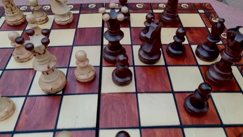 Pan down slow motion shot of chess pieces arranged neatly on a handmade / han Stock Footage 130976254