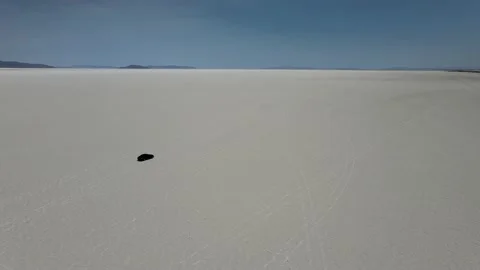 Pan Down on Utah Salt Flats to Car Driving Drone Shot Stock Footage 154133935