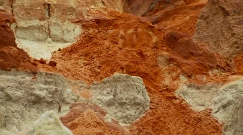 Pan down vividly coloured red and white rocks and sand dunes. Stock Footage 11437306