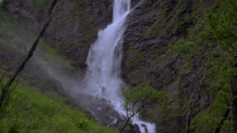 Pan down with waterfall in green mountain scape Stock Footage 141588552