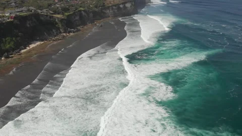 Pan down on waves near coast in Uluwatu, Bali 動画素材 260280048