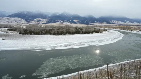 Pan downstream of Icy river below Montana Mountains Stock Footage 327698599
