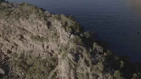 Pan drone overflight of rocky boulder, cliffs and Balearic sea, Raw in 4k Vidéo 89999618