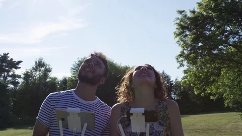 Pan From Drone Pilots On The Ground To Drone In The Air Slow Motion Outdoors Vídeo Stock 82589532