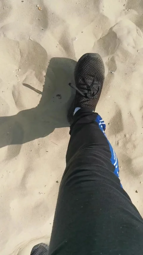 Pan up DSLR shot walking on the beach to the sea, in sunny England Stock Footage 153637256