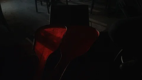 Pan up from an empty guitar case to a man of latino descent playing guitar Stock-Footage 117573806