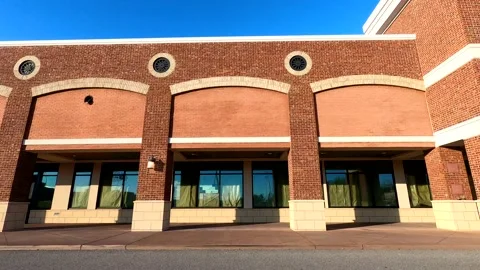 Pan of empty retail space for lease in a large shopping center on a clear blu Stock Footage 148059310