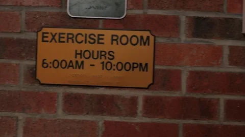 Pan of exercise room sign on a brick wall. Stock Footage 71621497
