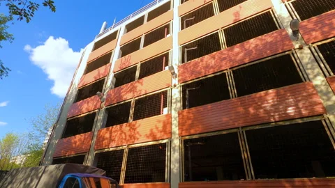 Pan exterior of a multilevel red brick parking lot with grilles without cars Stock Footage 241886321