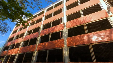Pan facade of a multilevel red brick parking lot with grilles without cars Stock Footage 243037082