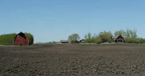 Pan of farm with a red barn and abandoned house. 動画素材 50150174