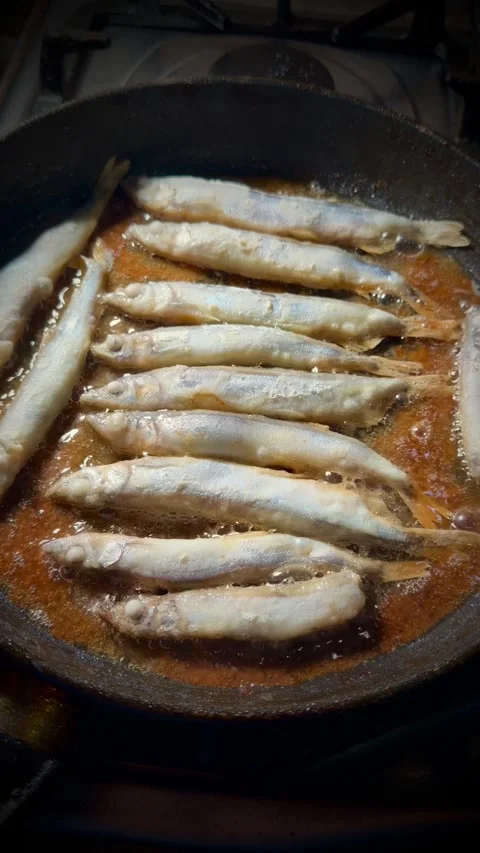 A pan of fish is cooking on a stove Stock Footage 329753023