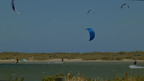 Pan follow several speeding kite surfers over waters of Safety Bay Stock Footage 229461647