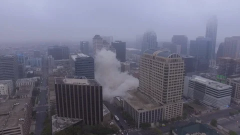 Pan Forward of Billowing Dust after Austin Building Implosion with Downtown Stock Footage 87668448