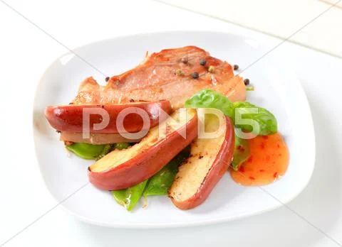 Pan fried belly pork and apple wedges Stock Photos