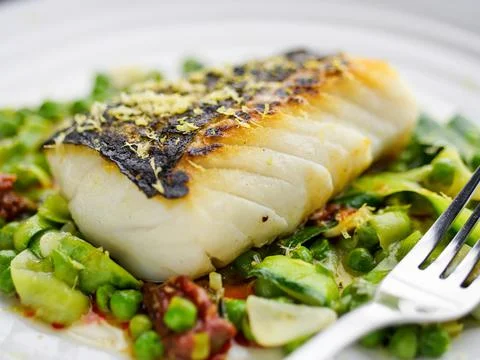 Pan fried cod peas and soft chorizo Stock Photos