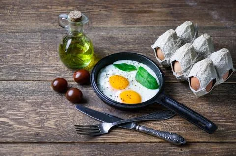 The pan fried eggs, cherry tomatoes and fresh spinach. Concept of a healthy Foto stock