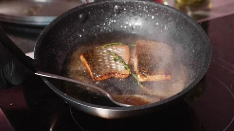 Pan-fried fish, Two pieces of loban fillet on the steaming frying pan. Stock Footage 93282606