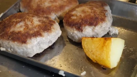 Pan-Fried Pork Cutlets with Roasted Potato Wedge on Metal Tray Stock-Footage 347688522