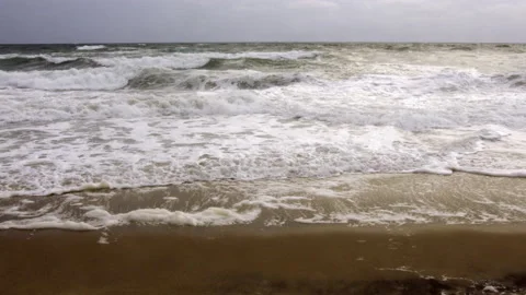 Pan Frothy waves, pounding surf, stormy ocean, winter storm, dark, cold grey sky Stock Footage 195694036