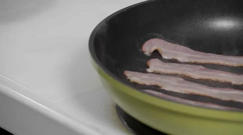 Pan frying Bacon on the stove top 스톡 동영상 57909702