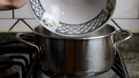 A pan full of flour. An hand stirring flour and water  Stock Footage 153896432