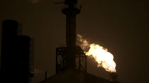 Pan from gas flame stack to smoke stack to night sky Stock Footage 89945461