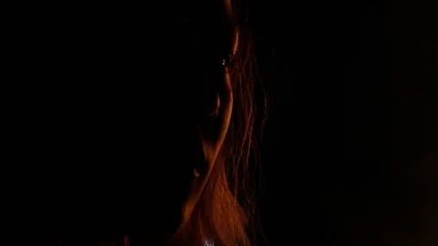 Pan to girl's face as fire lights and burns at it Stock Footage 122801791