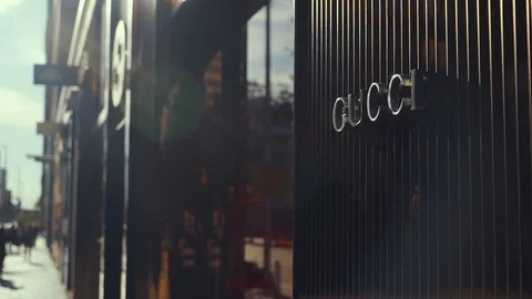 Pan from Gucci Logo on Storefront to People walking by Stock Footage 89958849