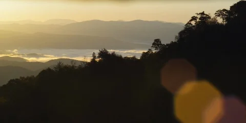 Pan of layers of mountain ranges covered with morning sunlight and fog Stock Footage 103396988