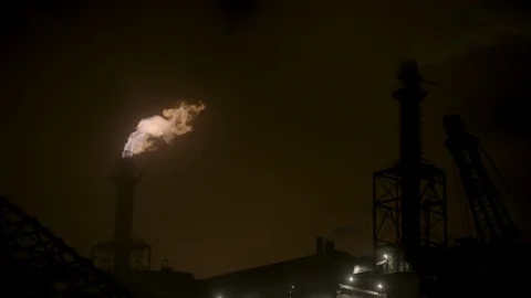 Pan left across night sky with steel mill fire smoke stack in background Stock Footage 89945375