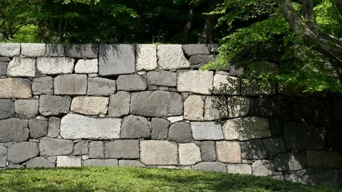 Pan left of an ancient stone wall at the imperial palace in tokyo Stock Footage