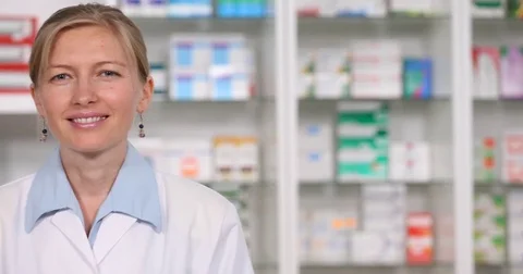 Pan Left Close Up Smiling Pharmacist Woman Looking Camera Salutation Hand Sign Stock Footage 72784507