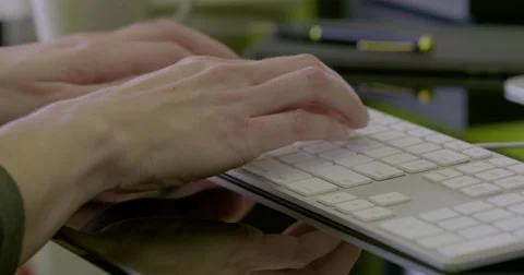 Pan left of female hands typing on keyboard Stock Footage 68446673