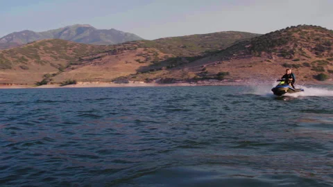 Pan left Full front to back shot of two guys riding one wave runner going ri Stock Footage 167803404