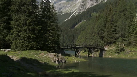 Pan to the left of a little bridge in the middle of the mountains Stock Footage 231468624