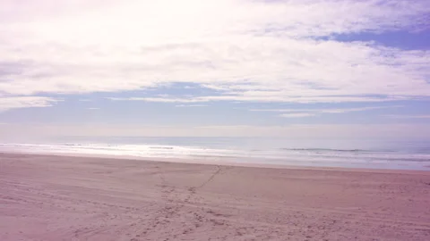 Pan left over a deserted gorgeous beach with blue sky, wispy clouds and Vídeo Stock 146149615